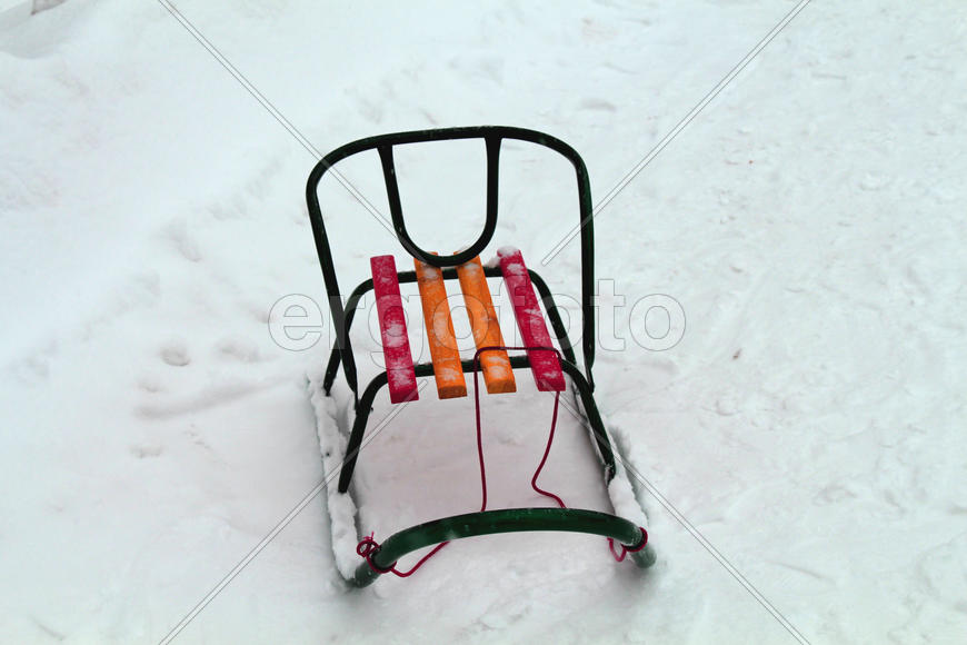 Зимние детские санки на снегу 