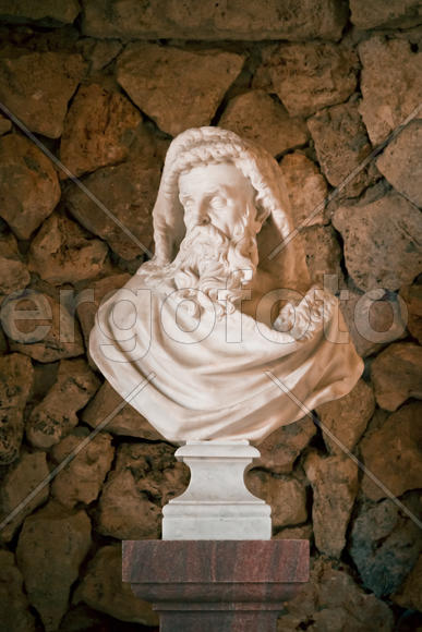 Бюст в античном стиле на фоне каменной стены