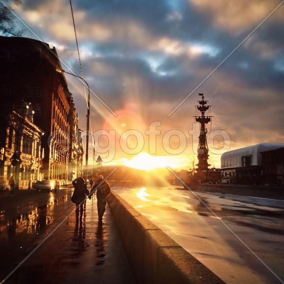 Пара гуляет на закате по набережной