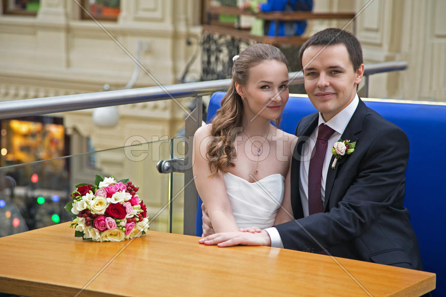 жених и невеста сидят за столиком в кафе