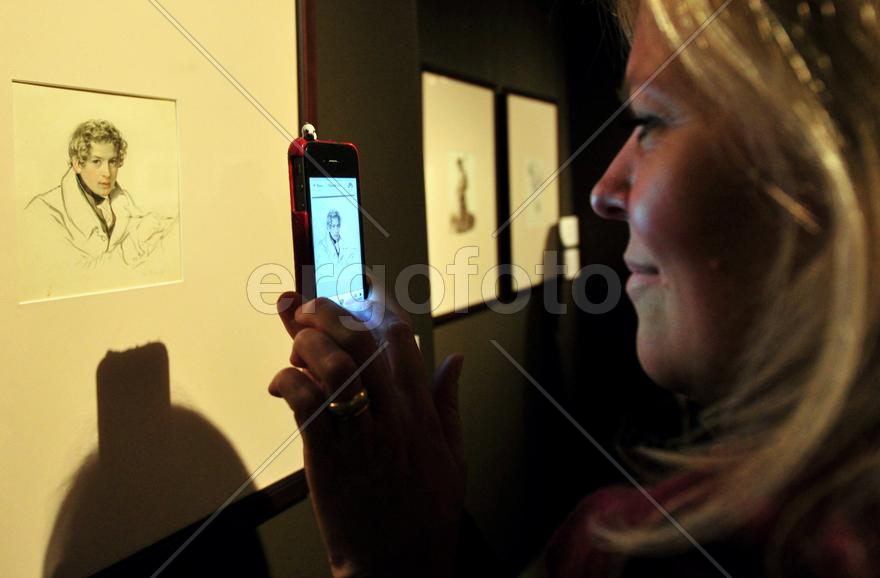 Девушка снимает картину на телефон