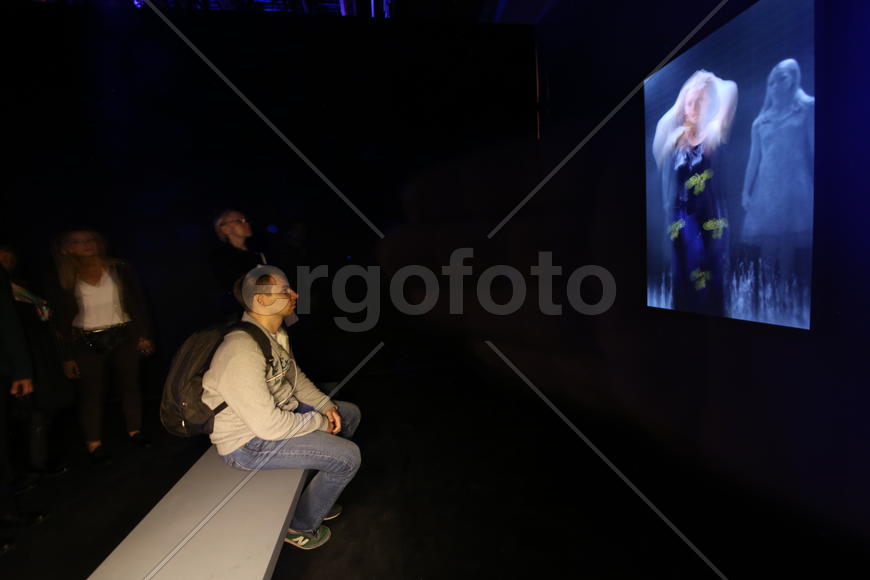 Зрители смотрят видео Билла Виолы "Три женщины" 6-ая ежегодная выставка гибридного искусства Lexus H