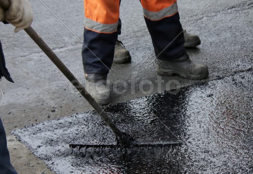 Заливка жидким асфальтом ямы на дороге