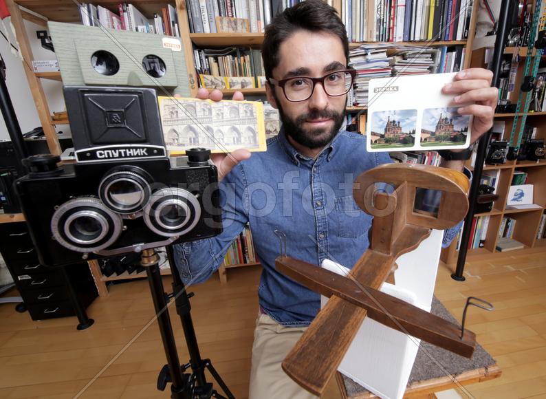 Историк Роман Шмидт демонстрирует открыики и фотографии с памятниками архитектуры 