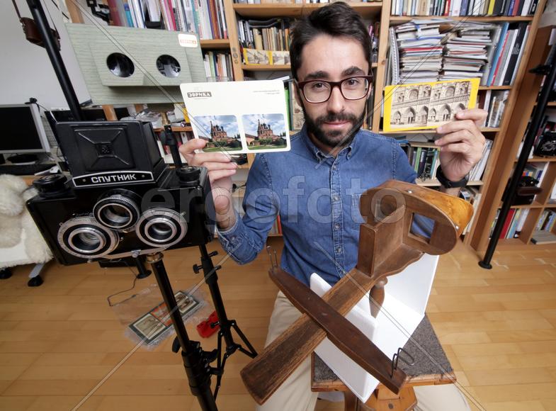 Историк Роман Шмидт демонстрирует открыики и фотографии с памятниками архитектуры 