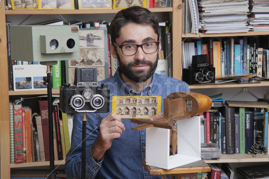 Историк Роман Шмидт демонстрирует открыики и фотографии с памятниками архитектуры 