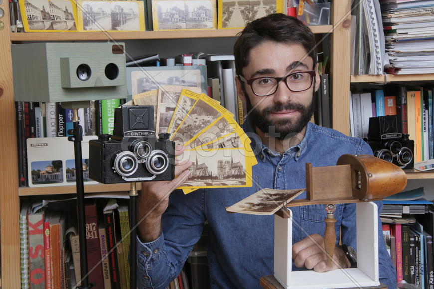 Историк Роман Шмидт демонстрирует открыики и фотографии с памятниками архитектуры 