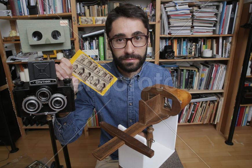 Историк Роман Шмидт демонстрирует открыики и фотографии с памятниками архитектуры 