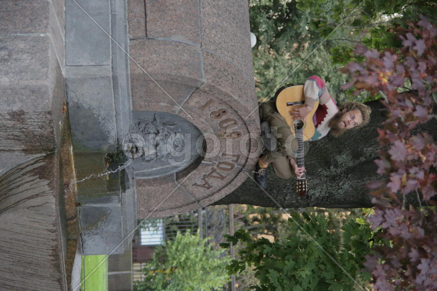 Уличный музыкант сидид на фонтане. Санкт-Петербург 2016 