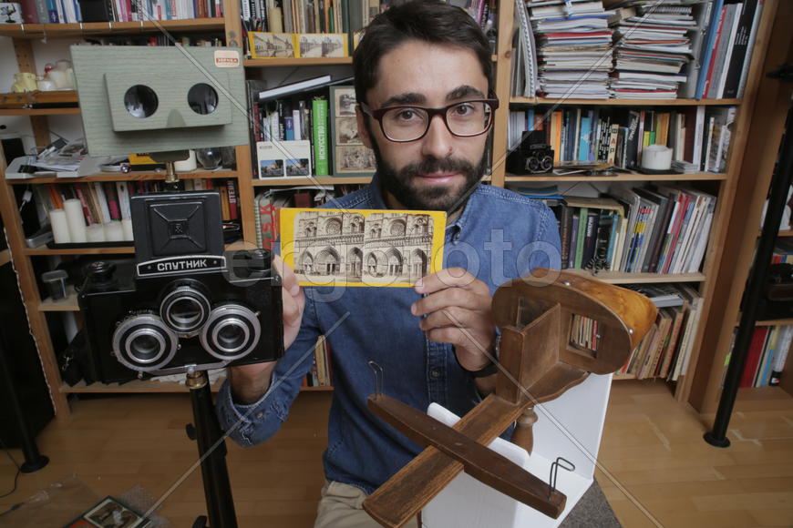 Историк Роман Шмидт демонстрирует открыики и фотографии с памятниками архитектуры 