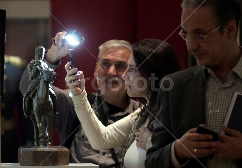 Дмитрий Коробейников показывает Галине Поминовой миниатюрную бронзовую спичку  у бронзовой миниатюры