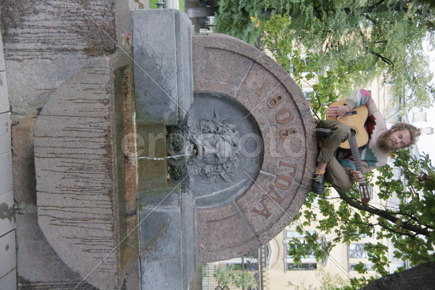 Уличный музыкант сидид на фонтане. Санкт-Петербург 2016 
