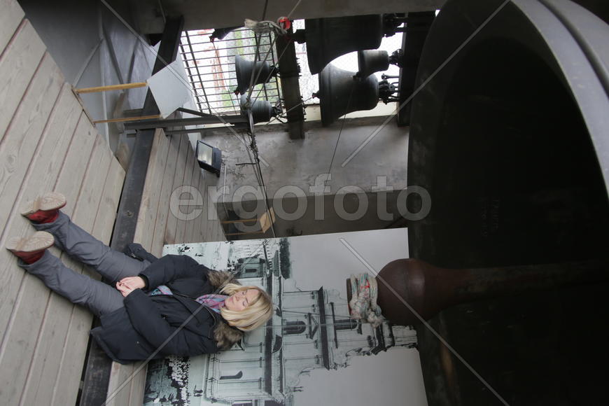 Санкт-Петербруг. Женщина сидит под огромным колоколом в колокольне 