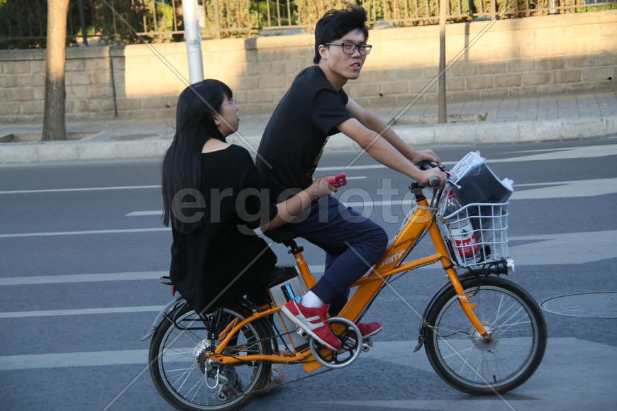 Пекин. Велосипед с электромотором и пассажиркой.