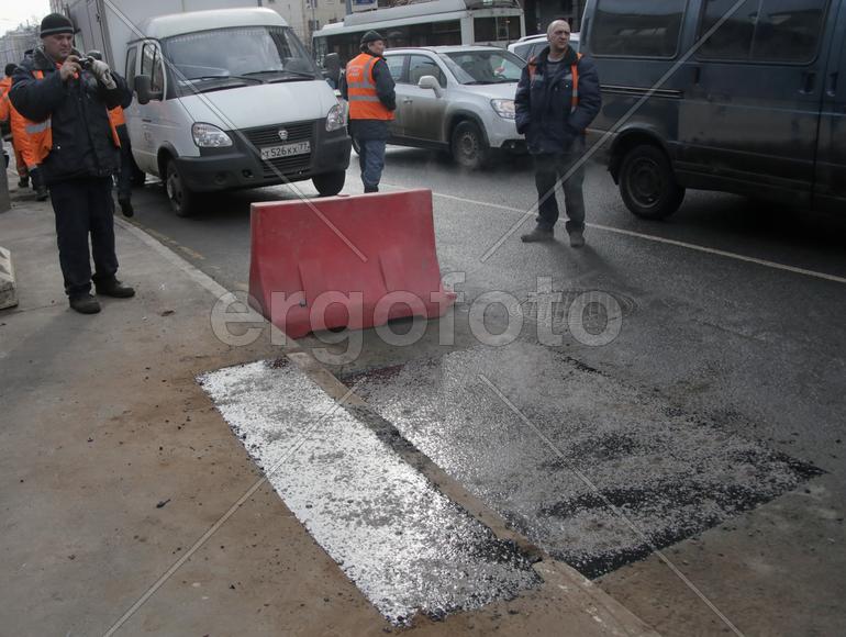  бригадир Роман Пеляницын,фотографирует заделанную яму. ул.Авиамоторная, дом 12.