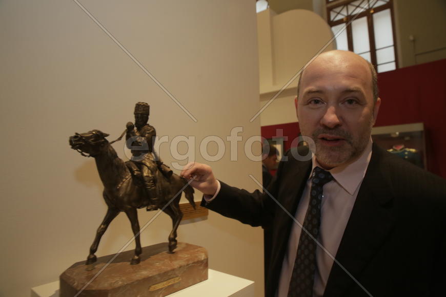 Коллекционер Константин Журомский у бронзовой миниатюры "Казак, закуирвающий трубку". 