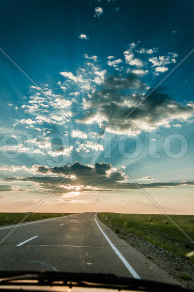 Восход солнца над трассой. Солнечные лучи пробиваться через облака 