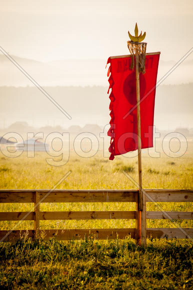 Забор в степи с красным флагом