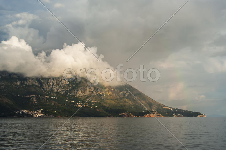 Облака лежат на горе в свете солнца
