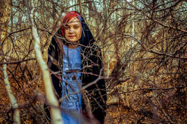 Девушка с яркими волосами в ветвях деревьев