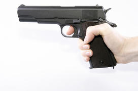 hand holding a gun on a white background isolated