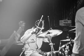 Барабанщик в маске играет на концерте