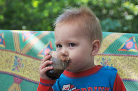 Мальчик пьёт из кружки на природе