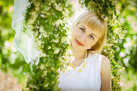 Девушка на качелях, обвитых зеленью