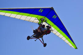 Trike, flying in the sky with two people. 