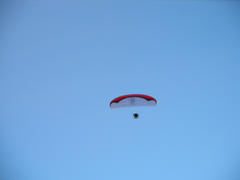 silhouette of unidentified skydiver parachutist on blue sky on sunset