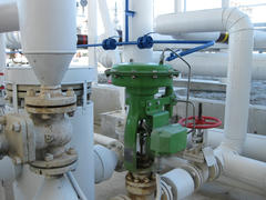 Green pneumatic valve on the pipeline. The equipment of the oil plant