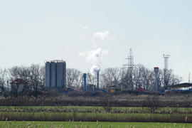 The smoke from the chimney of the plant. Industrial facility with a smoking pipe