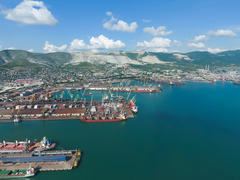 Промышленный морской порт, вид сверху. Портовые краны и грузовые суда и баржи