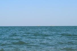 Море и два корабля на горизонте.