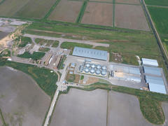 Plant for the drying and storage of grain. Rice plant in the middle of fields. Top view.
