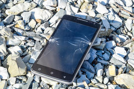 Разбитый телефон на гравии
