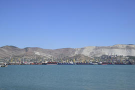 Грузовой порт с портовыми кранами. Морской залив и горные побережья.
