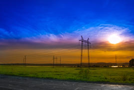 Электрические столбы и провода в контровом свете солнца 