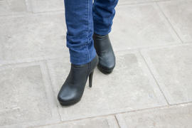 Girl's leg with black boots on a high heel. Street style