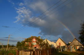 Радуга над деревней и частными домами 
