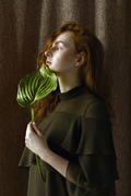 Портрет девушки с зеленым листок растения 