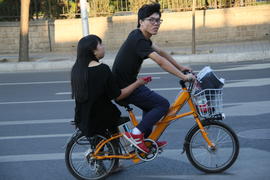 Пекин. Велосипед с электромотором и пассажиркой.