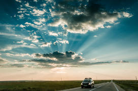 Восход солнца над трассой. Солнечные лучи пробиваться через облака 