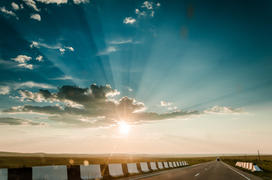 Восход солнца над трассой. Солнечные лучи пробиваться через облака 