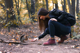 Девушка кормит белку